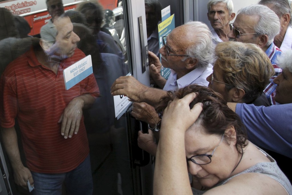 Numerosi pensionati al di fuori di una filiale della Banca Nazionale Greca: speravano di ritirare la pensione: pressano disperatamente un impiegato di banca a Iraklio, sull'isola di Creta, in Grecia, questo Lunedì.