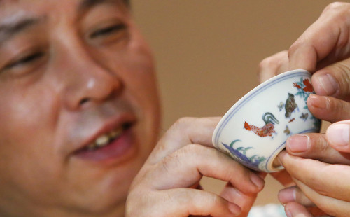 Liu Yiqian shows his Meiyintang 'Chicken Cup' from the Chinese Ming Dynasty (1368-1644) during Sotheby's Hong Kong Fine Chinese Ceramics